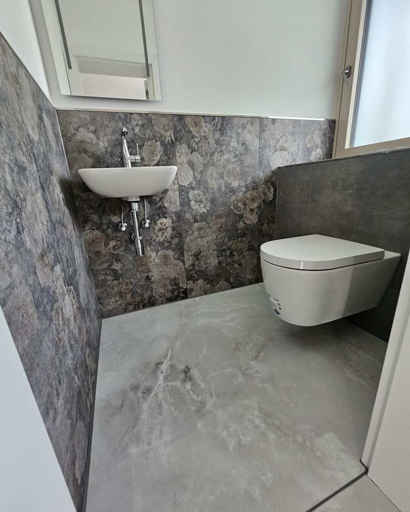 Gäste-WC mit Mikrozement-Akzentwand im Raum München