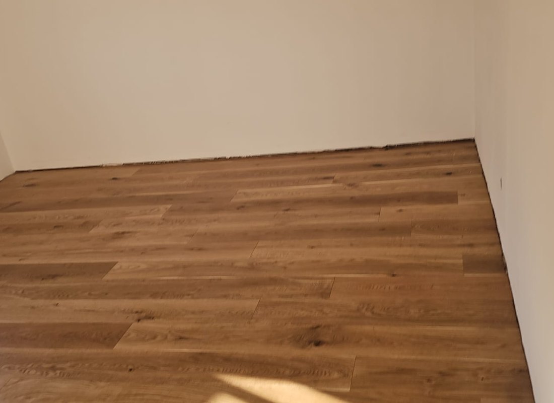 Detailaufnahme einer sauber ausgeführten Anthrazit-Wand mit Eichenboden und LED-Lichtkante
